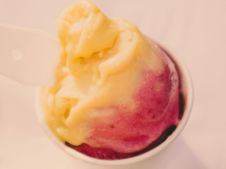 People holding a  Mango and Strawberry Ice Cream cone in a Summer Sunny Day with Green Background