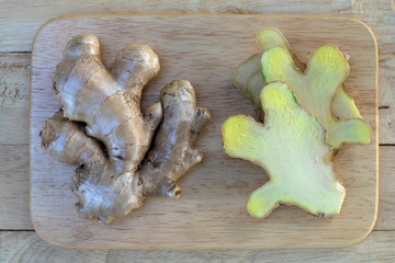 Fresh ginger on wooden chopping board, herb ingredient concept