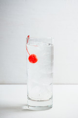 Bitter transparent cocktail with cocktail cherry. Selective focus. Shallow depth of field.