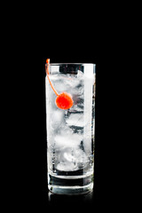 Bitter transparent cocktail with cocktail cherry isolated on black background. Selective focus. Shallow depth of field.