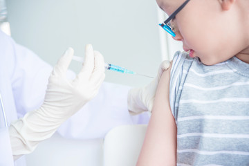 Closeup shot of a doctor vaccinating a boy in clinic.
