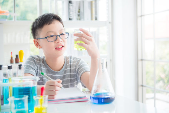 Young asian schoolboy doing chemistry experiment in laboratory classroom. Education concept.