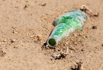 Glass bottle in the ground on the beach