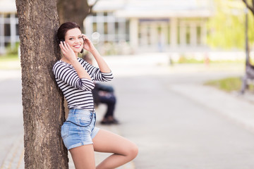 Young student leaning on a tree outdoors