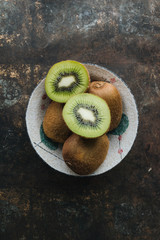 Green kiwi fruit on rustic background