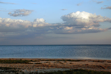 beautiful evening clouds over the sea on the wild shore