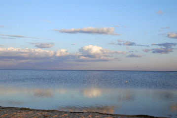 reflection of clouds in the calm sea in the evening at sunset