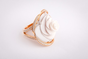 Gold women's ring with white stone in the shape of a rose with a white diamonds isolated on a white background.