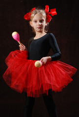 girl in black tights and red ballet tutu with maracas