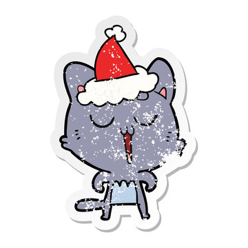 distressed sticker cartoon of a cat singing wearing santa hat