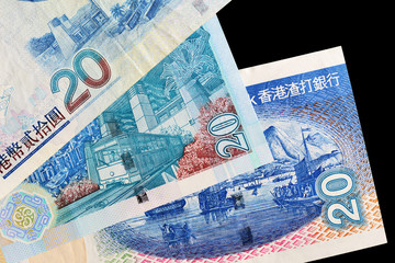 Three different bills in twenty Hong Kong dollars on a dark background close up