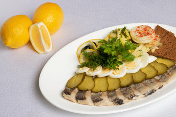 fish and vegetable cuts, pickled cucumbers,boiled eggs and lemon with micro greens