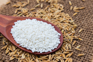 Raw peeling paddy rice on wooden table 