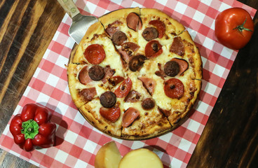 Pizza de carne en una bandeja de madera sobre la mesa