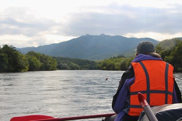 Travelers on raft swims on mountain Bystraya Malkinskaya river on the Kamchatka Peninsula, Russia.