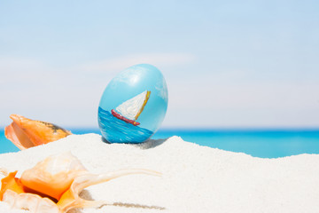 Easter on tropical beach background. Eggs on the white sand. Vacation and travel concept in spring