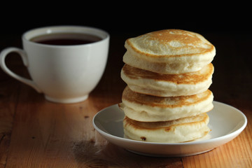 A stack of freshly backed pancakes and a cup of coffee	