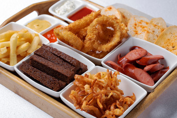 beer snacks of fried bread, onion rings and shrimps with sauce