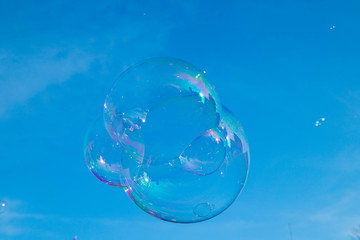 Soap bubbles in the air isolated on the blue sky 