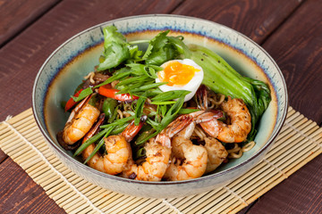  large and appetizing ready-made shrimps beautifully laid out with greens and vegetables for design solutions in cooking