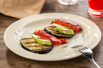 Grilled eggplant, zucchini, peppers sliced on wooden table