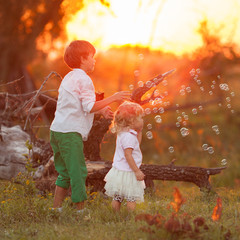 Pretty little girl and pink elephant. Girl playing with a soft toy on a photne of a summer field at...