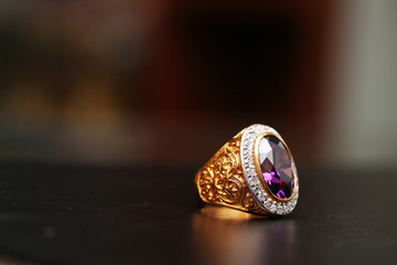 Purple gem stone on gold ring with diamond