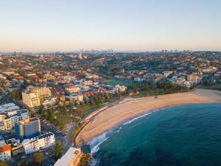Fototapeta premium Aerial view of Coogee Beach with Sydney skyline at the distance.