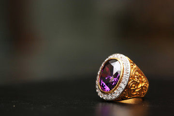 Purple gem stone on gold ring with diamond