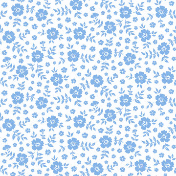 Seamless ditsy floral pattern in vector. Small blue flowers on a white background.