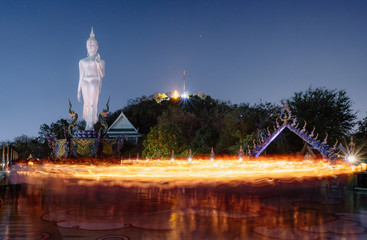 Fototapeta premium The candle lit ceremony around the Buddha image, Makha Bucha Day.
