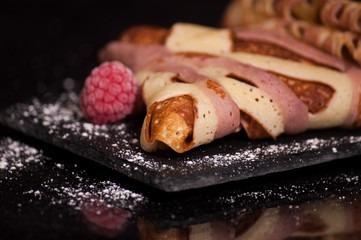 crepes on a plate with raspberries
