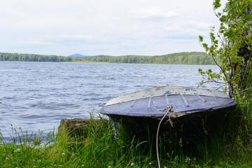 Naklejka na ściany i meble the boat on the bank of the lake