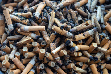 Cigarette butts background. Closeup of ashtray