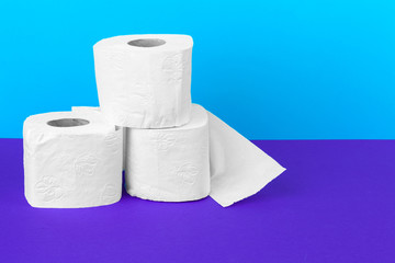 Toilet paper rolls isolated on white table with purple background