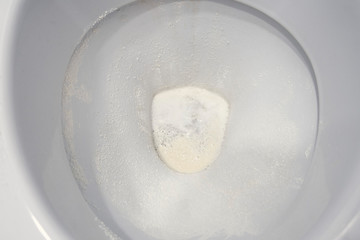 Toilet bowl sprinkled with detergent powder, close-up