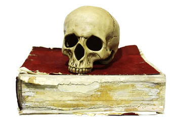Human skull on old book isolated on white background