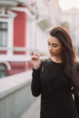 Fototapeta premium Sexy, young woman in the body smokes in the street