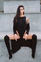 Sexy, young woman in leotard posing on camera in the streets