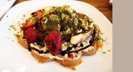 Sweet and delicious waffles with fruits and chocolate syrup 