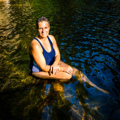Women talking a sun bath in a river - in Stanislaus National Park