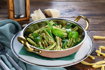 Pasta with pesto and pine nuts  on wooden background 