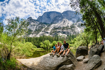 Family of four posing for a selfie in front of Mirror Lake and Half Dome in Yosemite National Park
