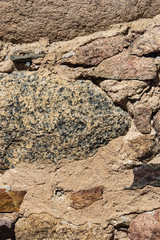 Old grey and brown rough stone wall, closeup texture background, selective focus, shallow DOF