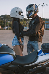 Fototapeta na wymiar Girl and guy bikers love each other. Fooling around and having fun. Love. Motorcycles, helmets, road, leather, sunset.