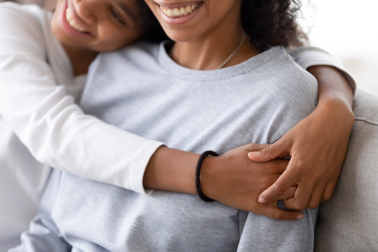 Cropped image of african daughter embracing mother
