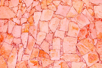 Closeup of trendy coloured living coral, orange and pink abstract sandstone mosaic wall. For pattern, texture and background