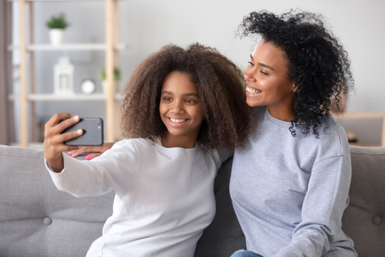 African different ages females sitting on couch make selfie photo