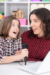 Portrait of mother and daughter singing karaoke