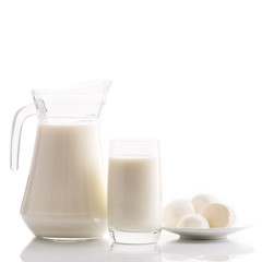 milk in a jug and glass and mozzarella cheese on a white background isolated